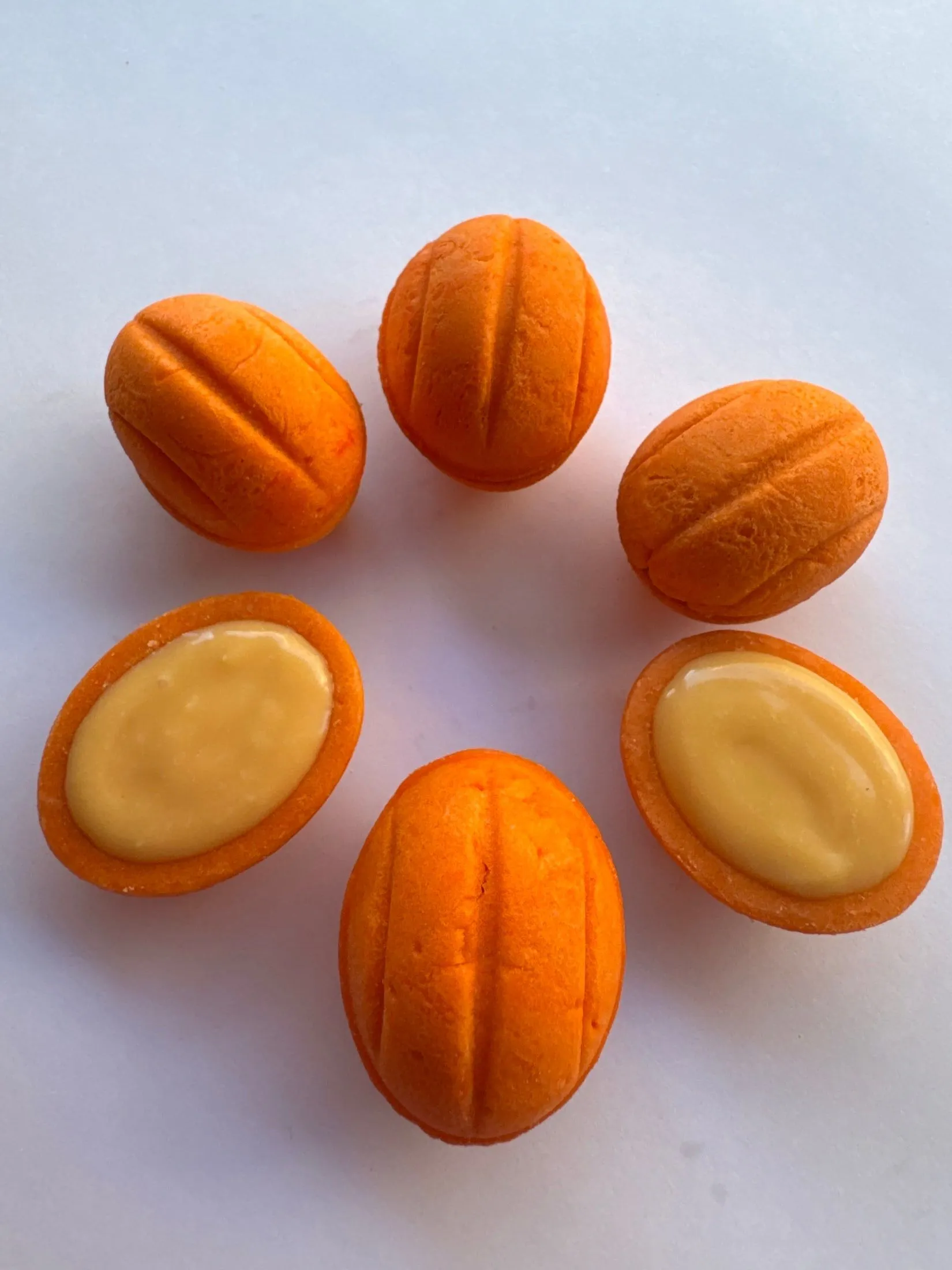 Oreshki naranjas, dos abiertos mostrando el relleno de crema de maracuyá